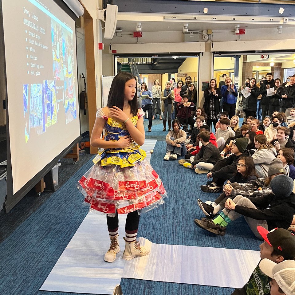Girl modeling dress made from food wrappers at fashion show - Trshion show dress made from pretzel wrappers and bread bags